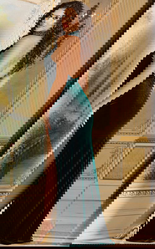 Model wearing Jovani 40119 green gown, back view showing sleek fit.