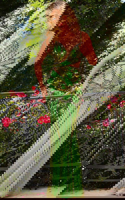 Model wearing Jovani 40129 green dress showcasing beaded design, front view.