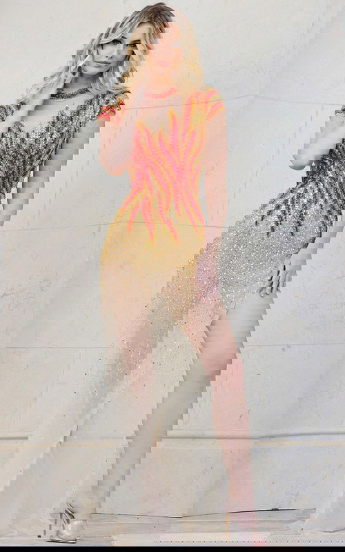 Model wearing Jovani 40157 nude dress with flame embellishments and high slit.