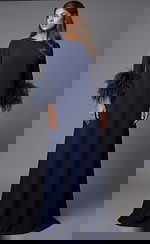 Floor-length navy gown with feather-trim sleeves and clean back silhouette