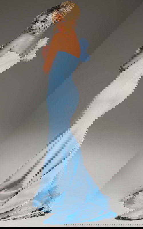 Model wearing Jovani 40201 blue mermaid dress with floral shoulder embellishment, back view.