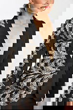 Close-up of beaded swirl pattern on blazer and structured deep V neckline.