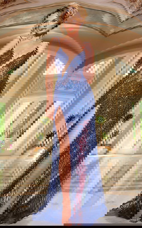 Model wearing Jovani 40276 navy gown with plunging neckline and high slit from the front.