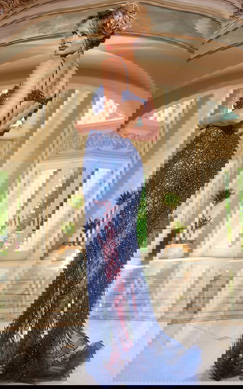 Model wearing Jovani 40276 navy gown with open back view.