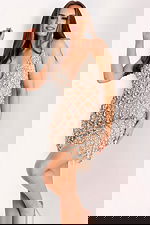 Party-ready nude mini dress with intricate beadwork and sparkling tassels