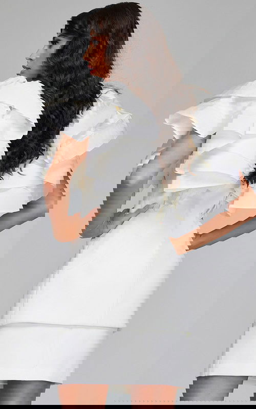 Model wearing Jovani 40292 ivory dress with ruffled sleeves, back view.