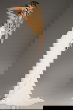 Model wearing Jovani 40301 ivory one-shoulder evening gown, back view.