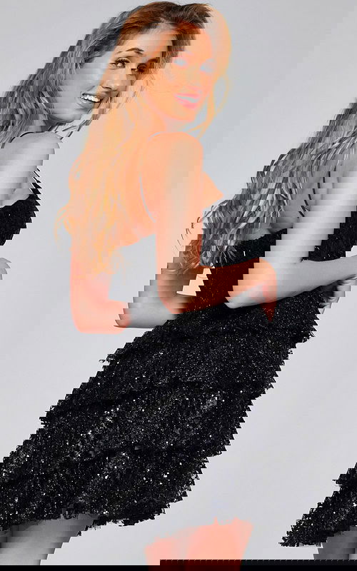 Model showing back view of Jovani 40386 black mini dress with tiered skirt.