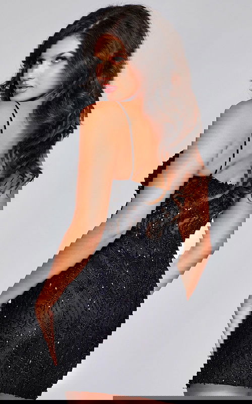 Model showcasing the back of Jovani 40498 black mini dress with low cut and lace details.