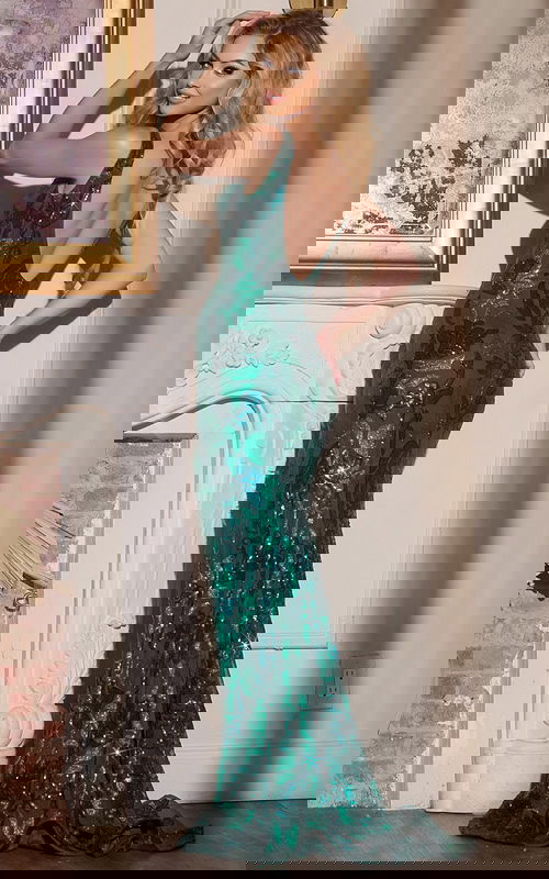 Model wearing Jovani 40757 green dress, back view highlighting low back design.