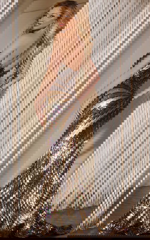 Back view of model in Jovani 40765 black and gold gown.