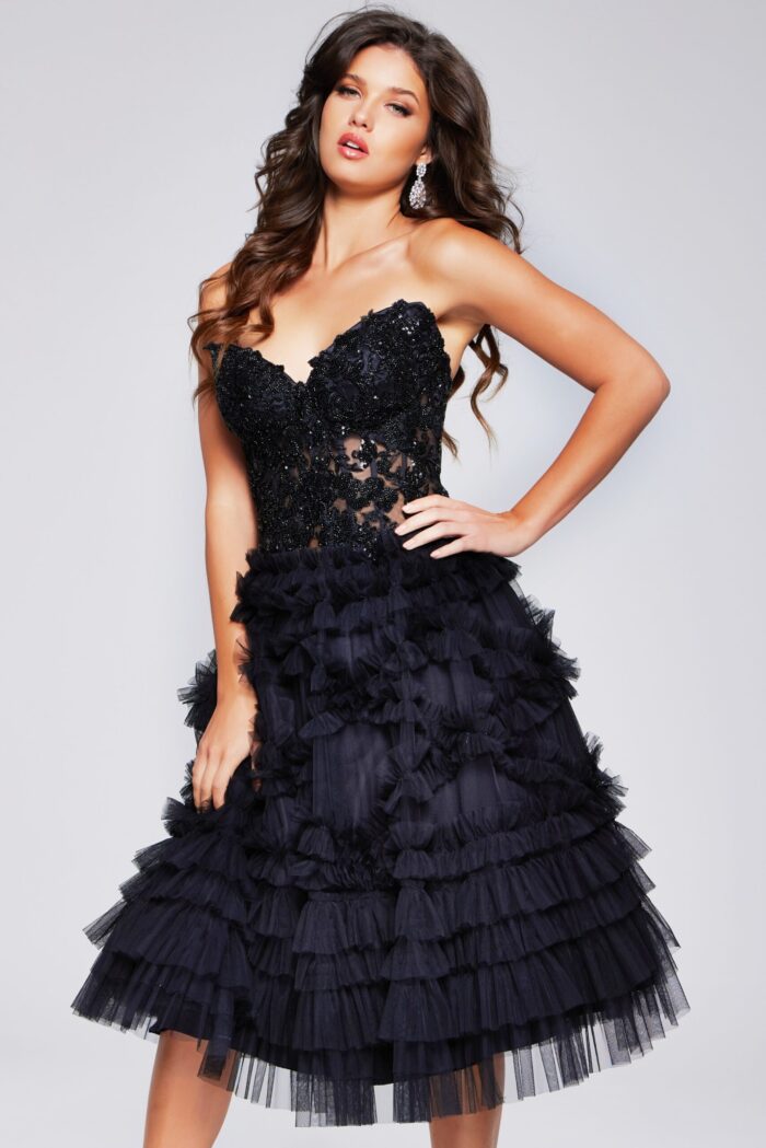 Model wearing Jovani 40854 black cocktail dress with lace applique bodice and ruffled skirt, front view.