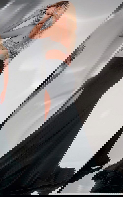 Back view of model in Jovani 40884 black gown showcasing fitted design and high slit