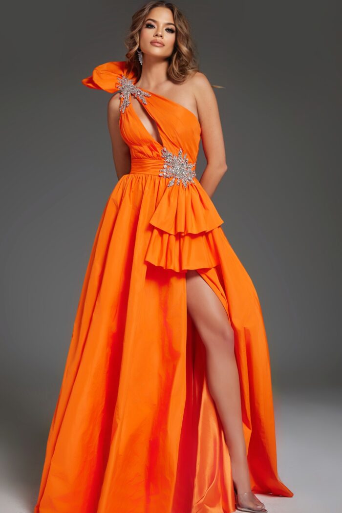 Model posing in Jovani 40929 orange dress featuring a one-shoulder design and silver accents