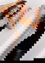 Woman in a black velvet gown with sheer side cutouts and thigh-high slit