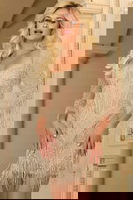 Model wearing Jovani 42007 nude mini dress with square neckline and fringe details.