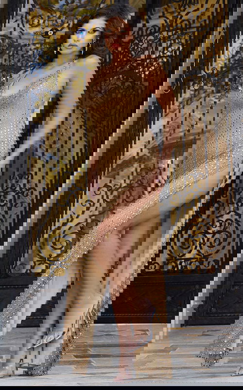 Model wearing Jovani 42015 gold gown with fitted silhouette and cowl neckline.