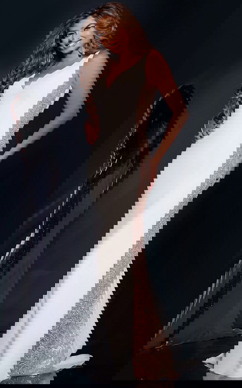 Model wearing Jovani 42025 elegant white gown with beaded sides and V-neckline, front view.