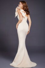 Back view of model wearing Jovani 32602 ivory gown with shoulder bow