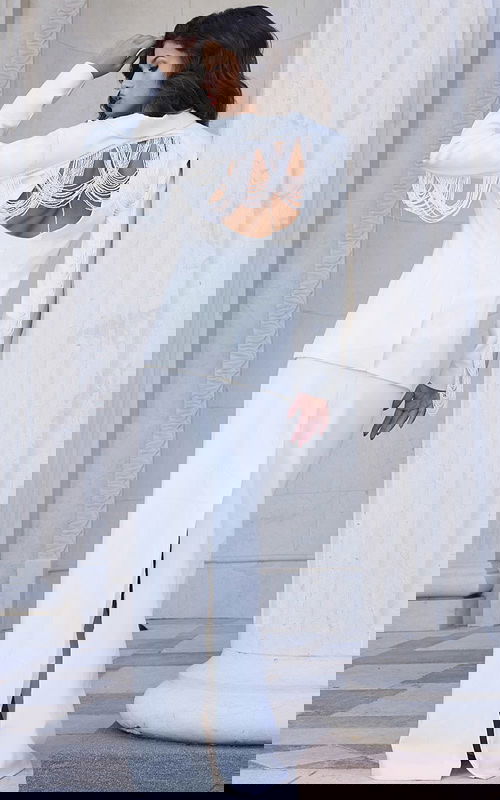 Back view of Jovani 42121 ivory gown showing open back and fringe detailing.