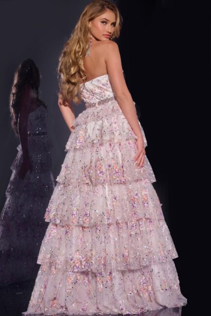 Back view of model wearing Jovani 42190 white dress with a tiered skirt and floral embellishments.