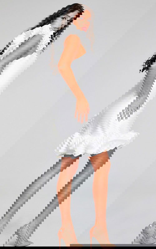 Model in Jovani 42348 side view of white mini dress featuring ruffled hem.