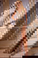 Model wearing Jovani 42512 nude beaded gown with V-neckline and high slit, front view.