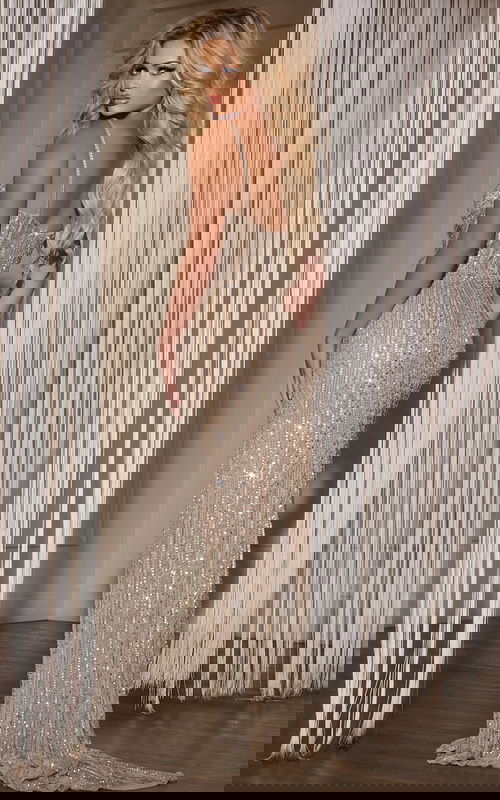 Rear view of model in Jovani 42541 nude gown showcasing open back design.