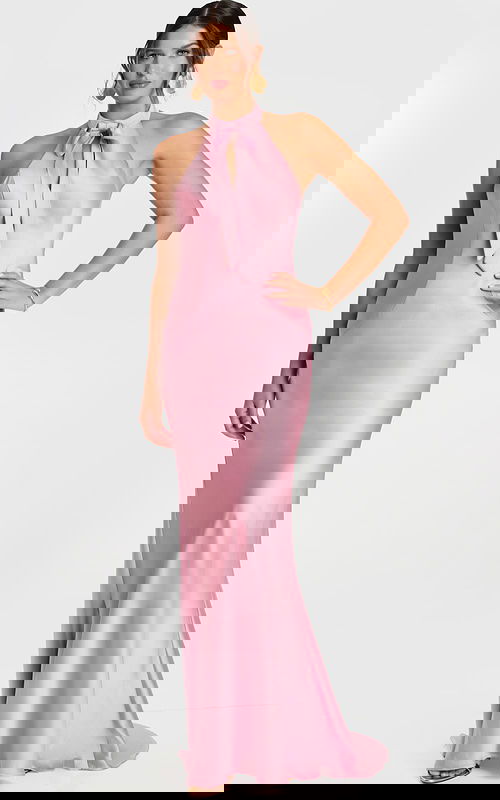 Woman wearing a mauve satin halter gown with a front bow tie and fit-and-flare silhouette.