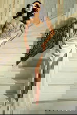 Model wearing strapless embellished gown with high slit on staircase