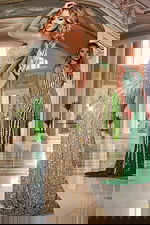 Model wearing Jovani 42677 gold gown with open back and sequins