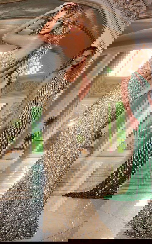 Model wearing Jovani 42677 gold gown with open back and sequins