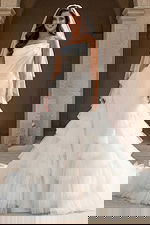 Front view of strapless bridal gown with dramatic layered tulle skirt