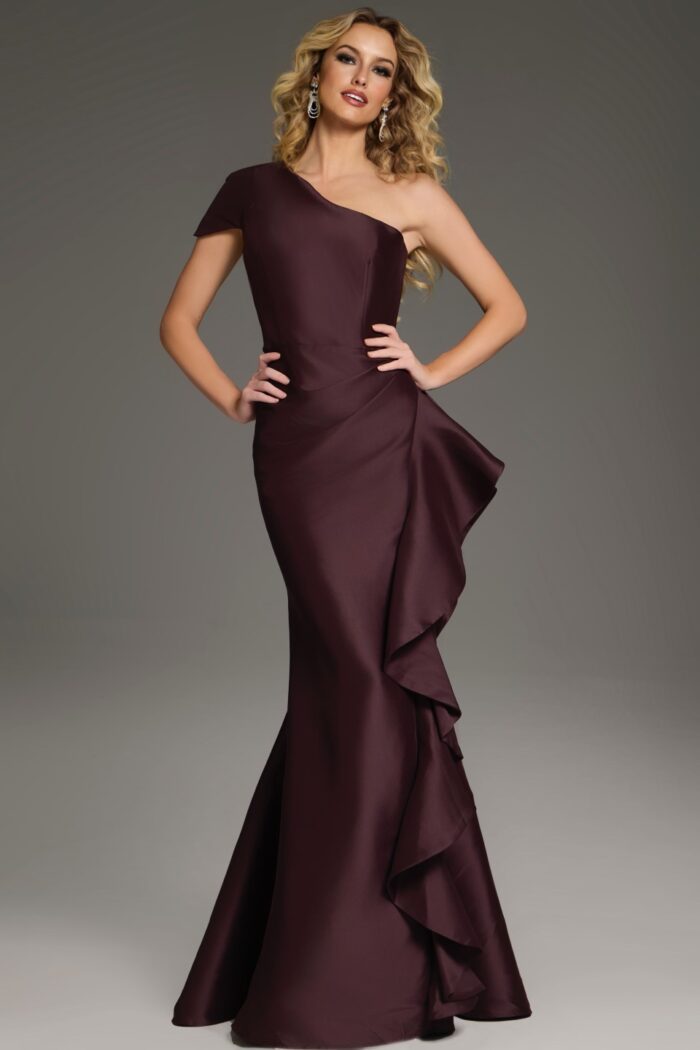 Model posing in Jovani 43126 dress in brown, featuring an asymmetrical neckline.