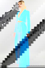 Woman wearing peacock blue tailored pantsuit with crop blazer