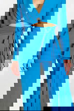 Close-up of rhinestone button and sash detail on high-waisted pantsuit