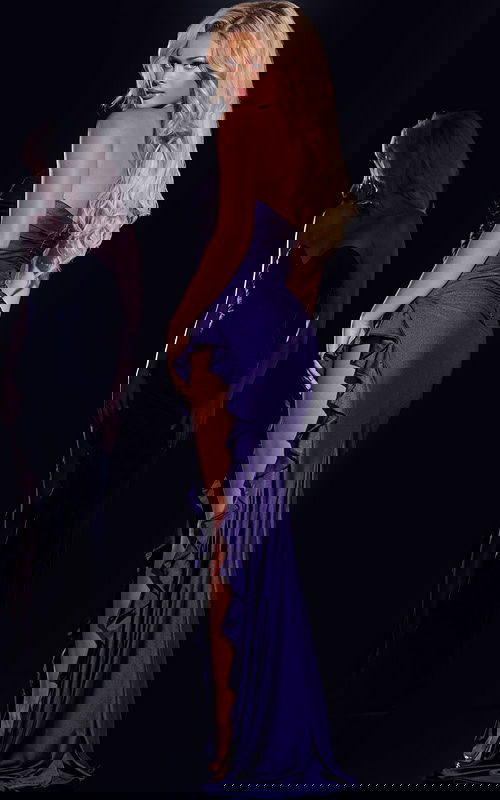 Model showcasing back view of Jovani 43143 purple gown with ruffle detail