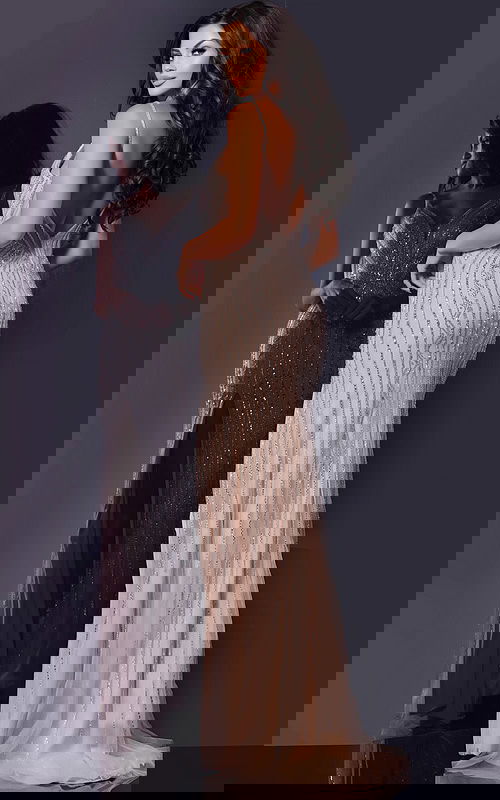 Model exhibiting back view of Jovani 43221 silver gown with open back design.