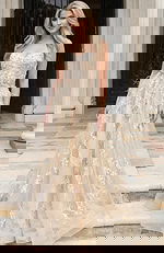 Front view of a strapless floral appliqué gown with layered tulle skirt