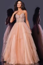 Model in Jovani 43254 blush gown featuring intricate embellishments and tulle layers