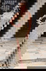 Front view of a beaded halter column gown with deep V neckline and high slit