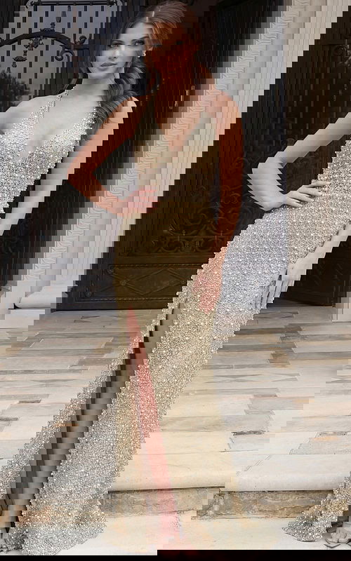 Front view of a beaded halter column gown with deep V neckline and high slit