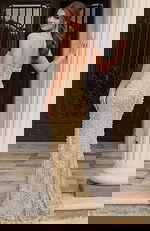 Back view of a beaded halter gown with open back and fitted column silhouette