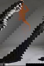 Back view of model in Jovani 43760 black lace mermaid gown showcasing strapless design.