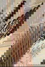 Shiny gold evening dress featuring plunging neckline and flowing skirt