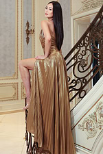 Shiny gold evening dress featuring plunging neckline and flowing skirt