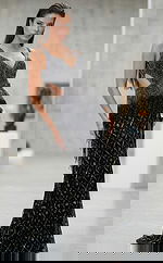 Angled view of a fitted gown with side cutouts, detailed bead patterns, and a floor length silhouette