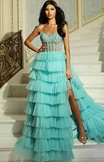 Model wearing strapless beaded corset gown with tiered tulle skirt