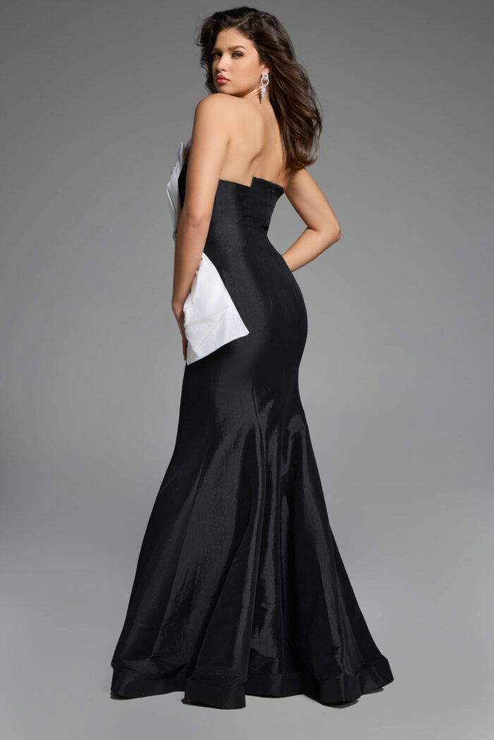 Back view of strapless black mermaid gown featuring a dramatic white bow accent.