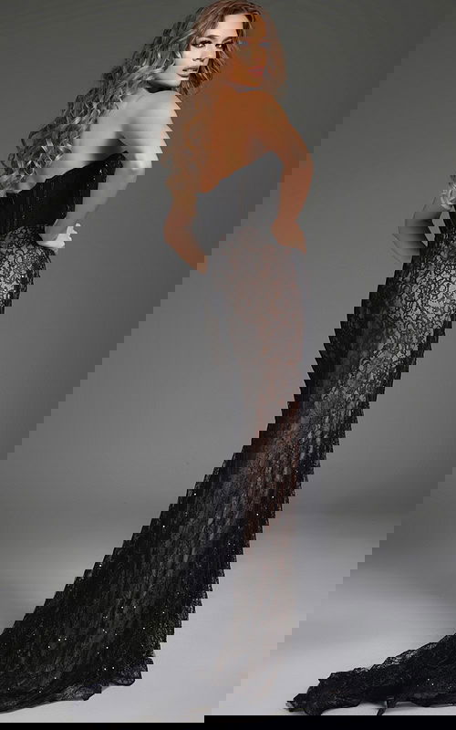 Model wearing Jovani 44609 back view, black lace elegant gown.